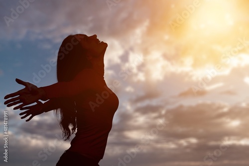 Young woman looking up feeling energized by the warm rays and sky