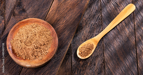 Myristica - Organic nutmeg powder in the wooden bowl