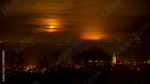Sobótka i pełnia księżyca na nocnym niebie, łuna miasta Siechnice