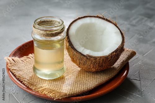 Coconut Oil in glass jar with Coconut cut open in half. pure homemade extra virgin coconut oil from Kerala India. Indian cooking oil.