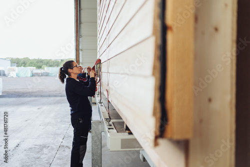 Female worker in a woodworking factory adjusting tie downs