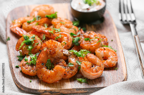 Wooden board of tasty shrimp tails on table