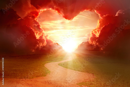  Red heart shaped clouds at sunset. Beautiful landscape with road. Love background with copy space. Road to love