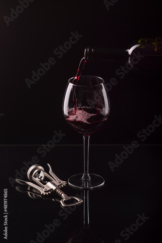 glass goblet of red wine on a black background