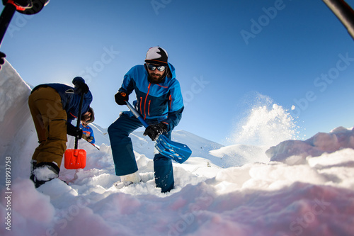 men with shovels digging the snow. Checking the mountain for avalanche safety.