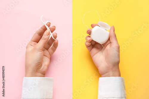 Woman with dental floss and toothpick on color background