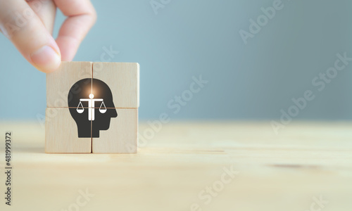 Business ethics concept. Ethics inside human mind. Business integrity and moral. The wooden cubes with ethics inside a head symbols on grey background and copy space. Company ethics culture. ESG.