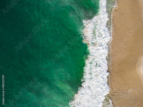 Aerial view of Barra da Tijuca Beach, a paradise in the west side of Rio de Janeiro, Brazil. Greenish sea waves and sand. Top view. Sunny day at dawn. Drone Photo