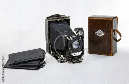 Vintage camera made in the USSR in 1935 with cassettes and a brown leather case on a white background