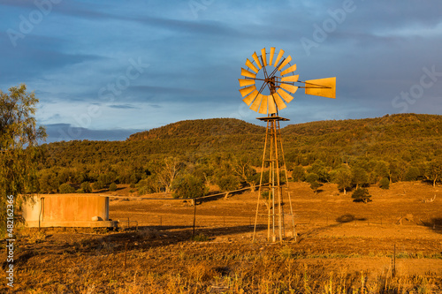 A water pump windmill on a rural farm, late afternoon, in Outback Australia.