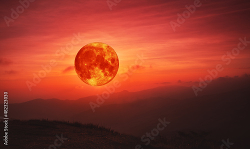 blood moon concept of a red full moon in red sky with cloud.