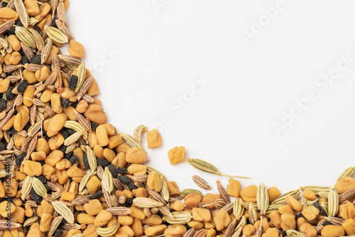 Panch phoron or panchpuran tradicional Indian five spice seeds blend for cooking consisting of fenugreek, fennel, cumin, mustard seeds, onion seeds or black cumin on white as food background