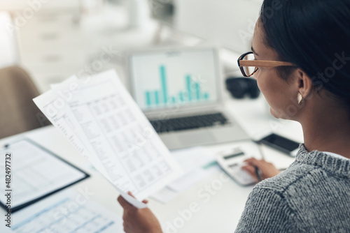 Busy with her tax return filing. Closeup shot of an unrecognisable businesswoman calculating finances in an office.