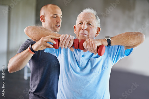 Just a little higher. Shot of a physiotherapist helping a senior man with weights.