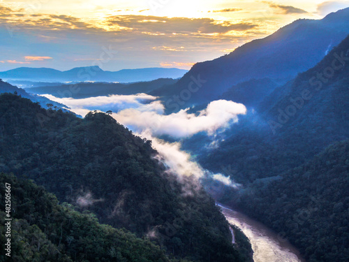 Misty rainforest with clouds over river at sunrise in Peruvian Amazon Basin/ Tarapoto