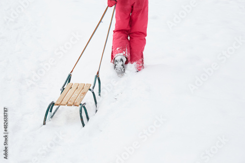 dziecko ciągnące sanki w zimie
