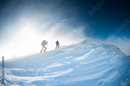 climbers climb to the top of the mountain in winter