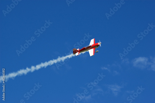 Model of acrobatic airplane flying in a blue sky