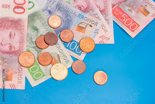 Swedish krona banknotes of different denominations and coins on a blue background