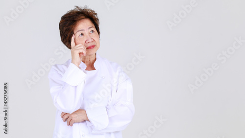 Elegant senior woman as professional chef confidently standing feel upset and worry in restaurant kitchen