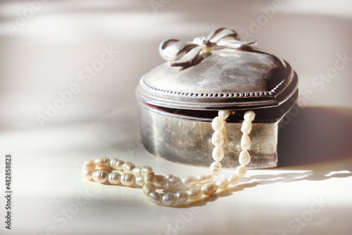 Old vintage silver jewelry box in heart shape. Strands freshwater pearls. Bridal accessories. Marriage concept.