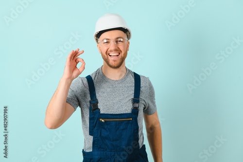 Craftsmen or electrician man over isolated blue background showing an ok sign with fingers