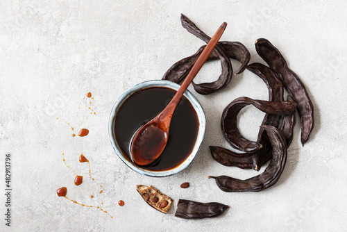 Healthy organic sweet carob pods with seeds and syrup