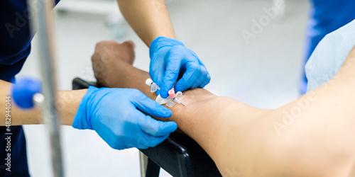 Placement of a catheter in the patient's arm for intravenous administration of drugs and saline. Selective focus.