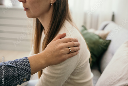 a gesture of support. a woman's hand on the shoulder of a distressed female patient. psychological help for women