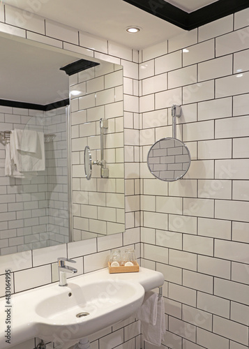 cuarto de baño azulejo blanco con lavabo y espejo hotel 4M0A0194-as22