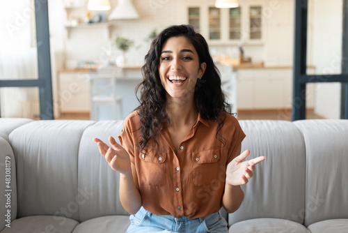 Headshot of happy young woman speaking to her friend on computer webcam, communicating remotely from home