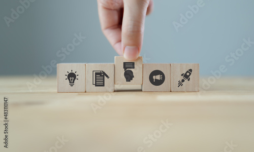 Storytelling concept. Content marketing strategy. Content visualization and visual marketing. Hand puts wooden cubes with marketing storytelling icon with idea, content, sharing and viral icons.