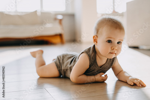 8 months old baby crawling on the floor at home.