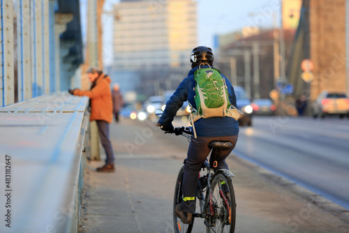 Mężczyzna jedzie na rowerze z plecakiem po moście Grunwaldzkim we Wrocławiu. 