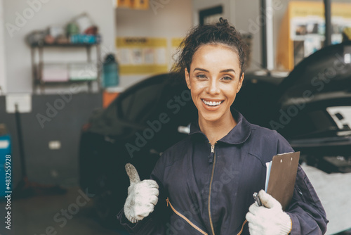 happy woman worker working for car auto service trumbs up smiling