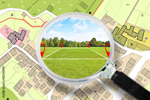 Searching a free Land plot with a vacant land available for building construction - Concept seen through a magnifying glass - note: the map is totally invented and does not represent any real place