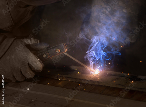 a male welder sits with an electrode holder in his hand. welding seam concept..