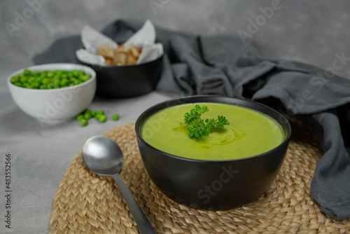 Summer cream soup with green fresh pea shoots.