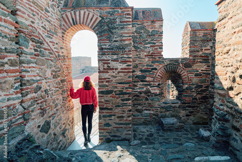 Traveler girl on the viewpoint of a byzantine castle Heptapyrgion in Thessaloniki. The concept of tourist landmarks in Greece
