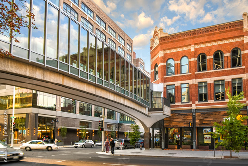 Pedestrians cross the street under the enclosed pedestrian bridge near the Bennett Building in the downtown district of Spokane, Washington.