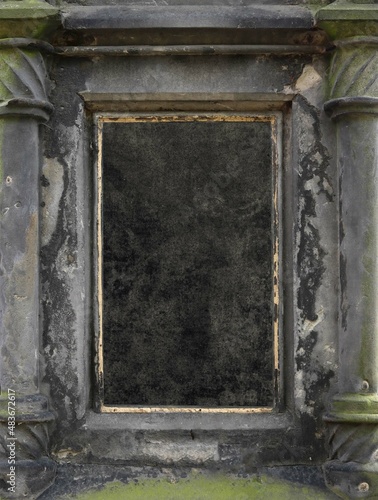 blank black old surface with a worn gold frame on a weathered stone decoration of an ancient monument with columns, such as a mausoleum or a graveyard - epic background for an epitaph