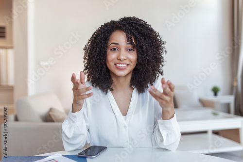 African-american elegant female entrepreneur discussing while having a conference call Portrait of confident ethnicity female employee looking at camera talking on video call in the home office.