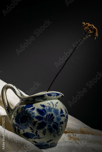 delft blue jug with withered flower