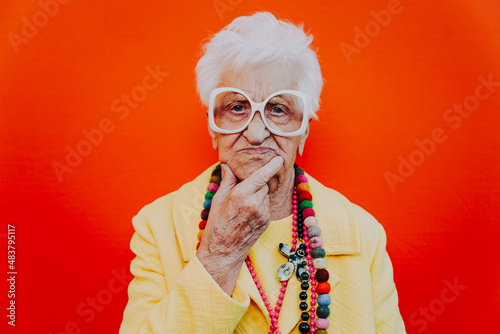 Śmieszne portrety babci. Starszy starsza kobieta ubiera się elegancko na specjalne wydarzenie. modelka babci na kolorowym tle