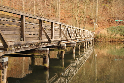 an old wooden bridge over a lake 