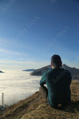 Traveler hiking in mountains clouds landscape