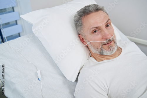 Man receiving supplemental oxygen through nose tubes