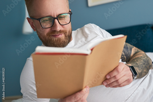 Positive man reading book at home