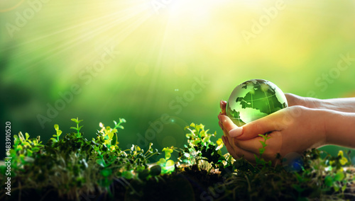 Environment day, save clean planet, ecology concept. Earth Day.Hand holding crystal earth globe.Renewable energy-based green businesses can limit climate change and global warming.