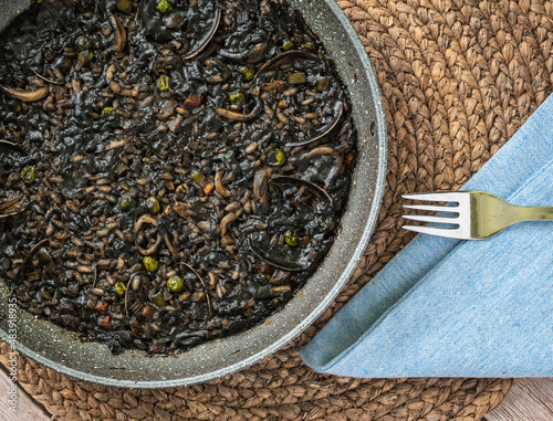 Black rice, paella served at a table